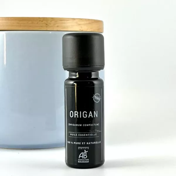 Flacon d’huile essentielle d’origan BIO Olessen devant un pot en céramique