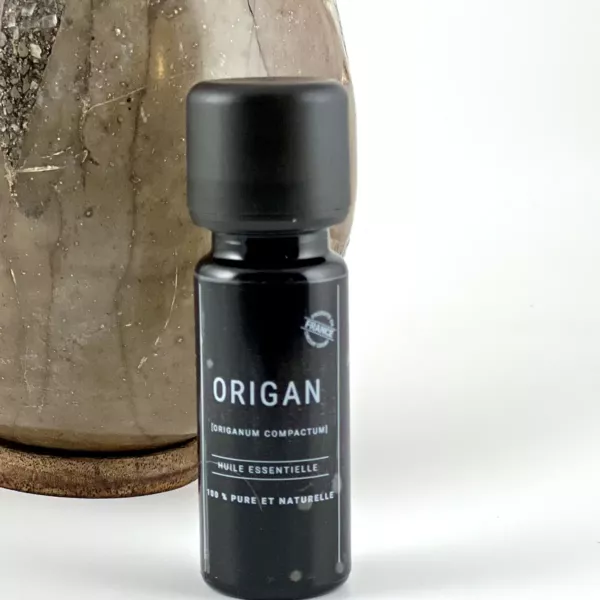 Flacon d’huile essentielle d’origan Olessen à côté d’un vase en céramique